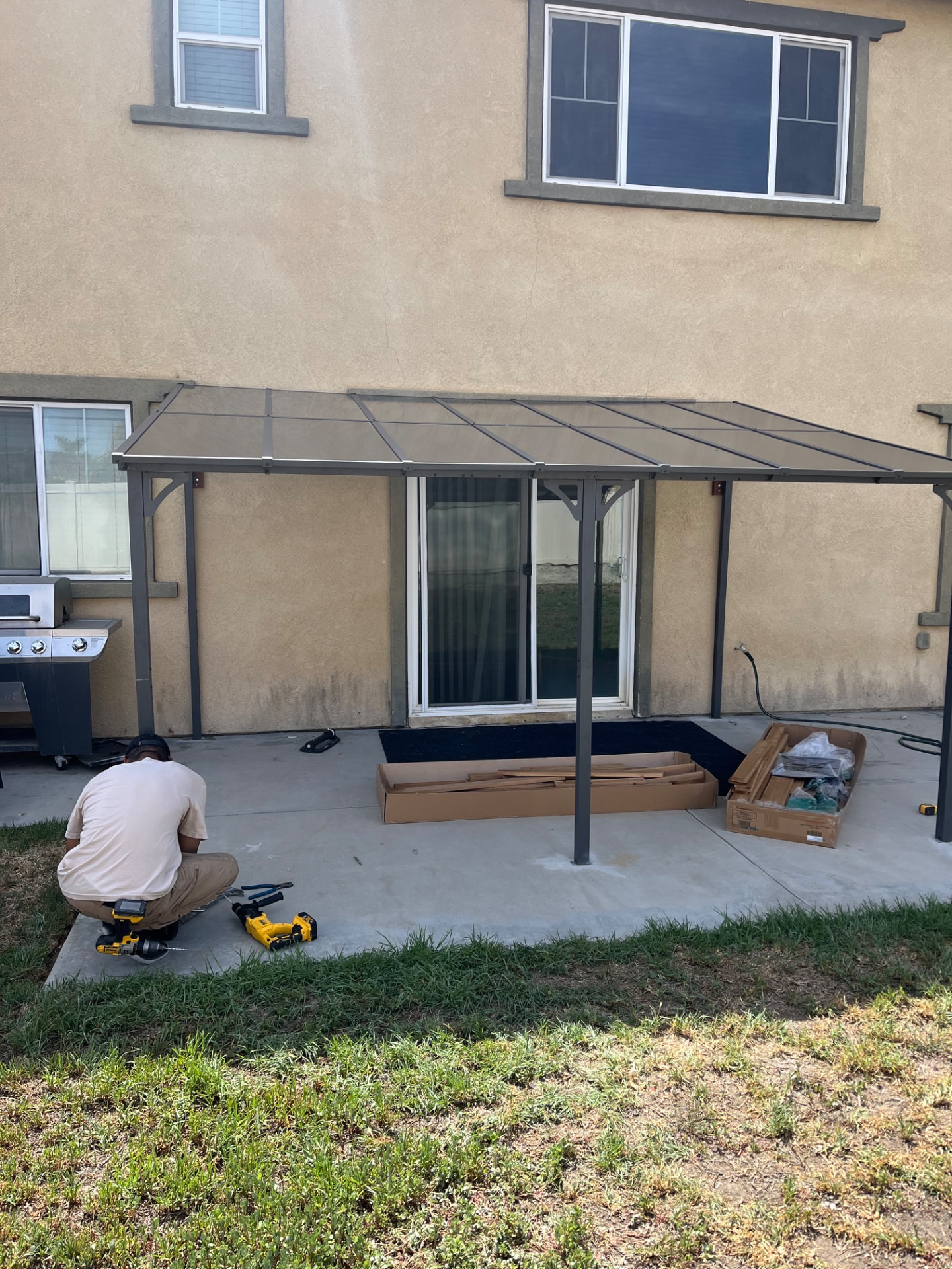 Finished patio cover with steel posts and translucent panels shading the back patio