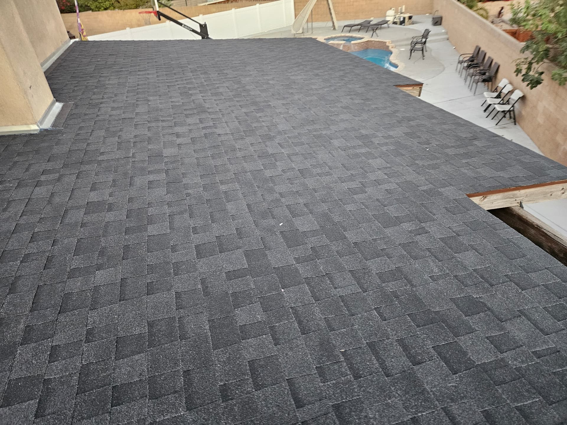 Finished deck roof with new charcoal architectural shingles overlooking the pool patio