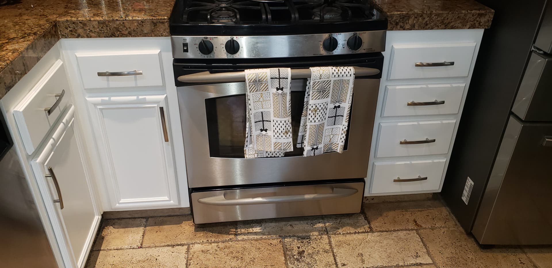 Same kitchen range wall with cabinets refinished in bright white and new brushed nickel hardware